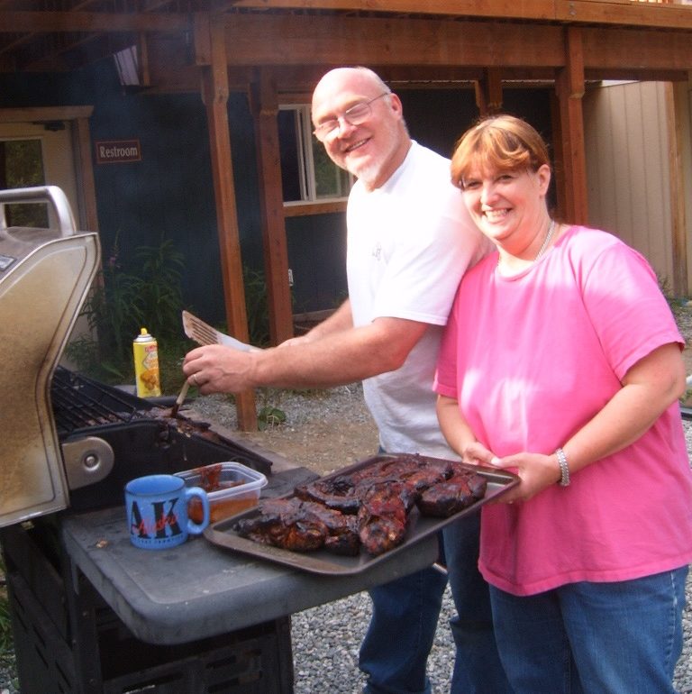 People standing in front of BBQ grill
